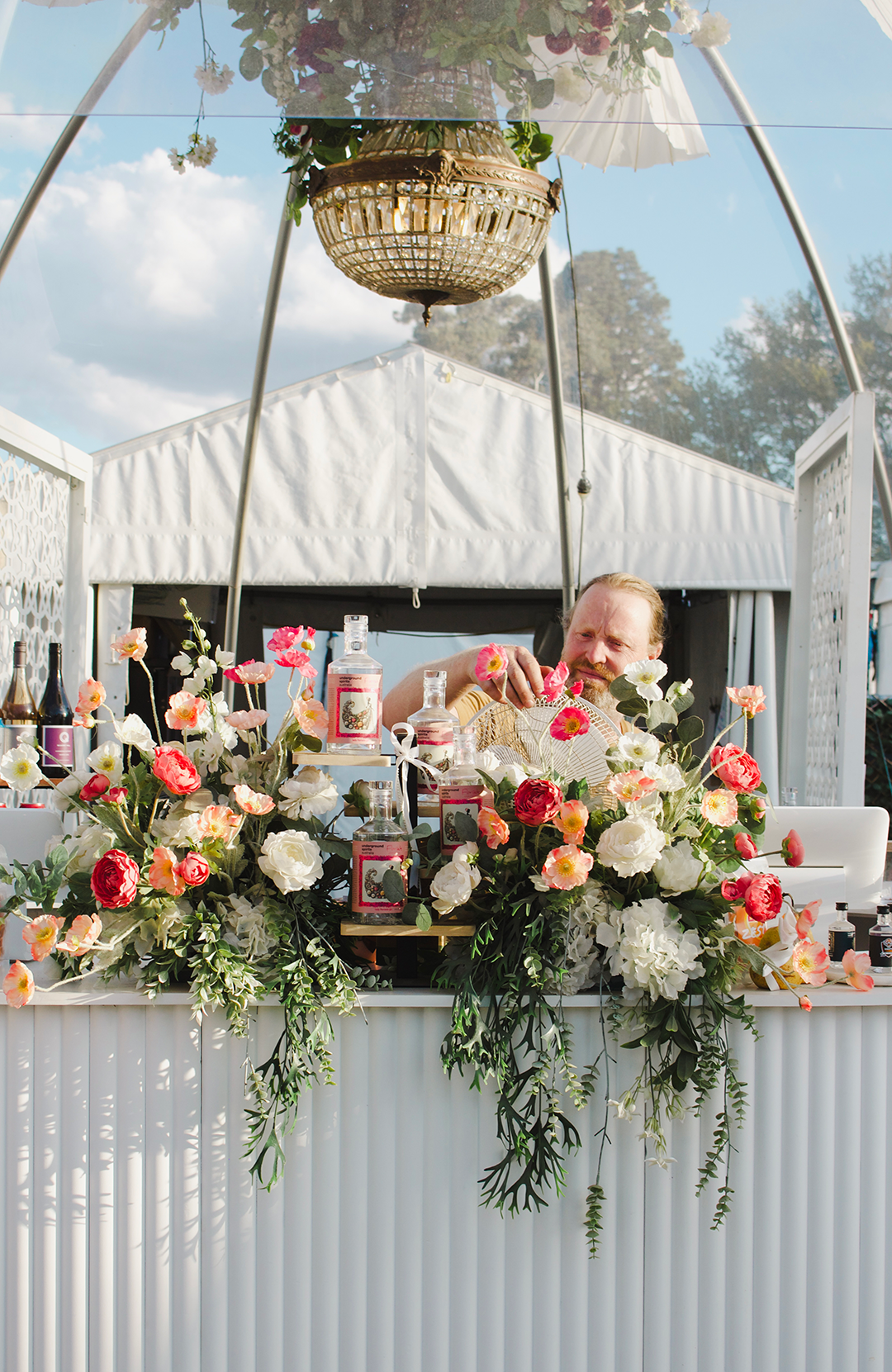 Underground Spirits bar with floral decorations and a chandelier in an outdoor setting at Floriade